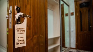 Een hotelkamerdeur met een bordje waarop gasten verzocht worden hun kamer schoon te houden.