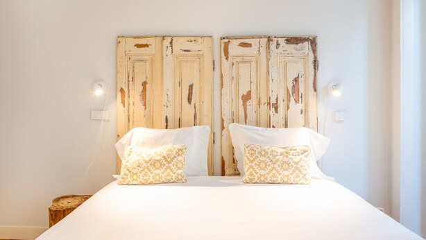 Un dormitorio con una cama grande, dos almohadas y un cabecero de madera.