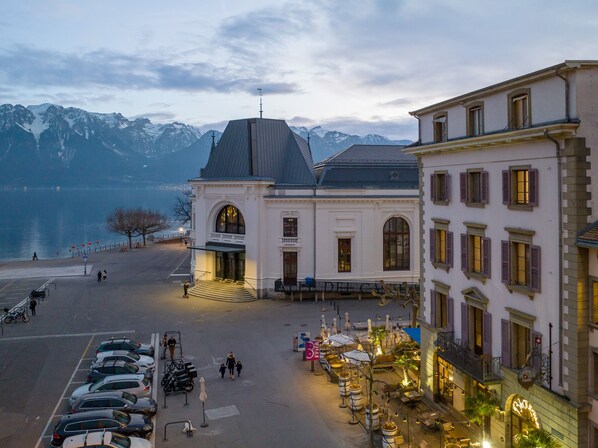 A hotel with a prominent entrance, a balcony, and a view of mountains.
