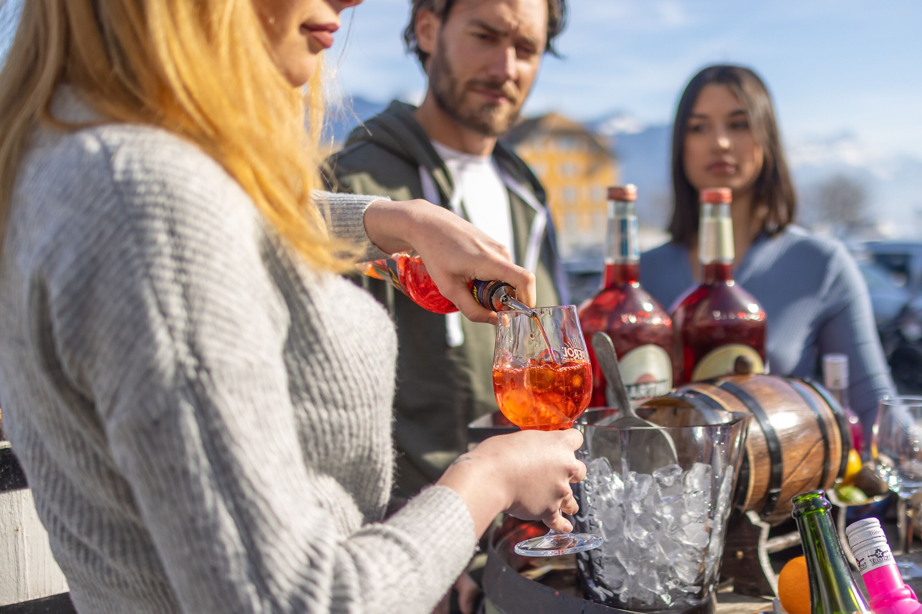 Une personne verse une boisson dans un verre contenant des glaçons.