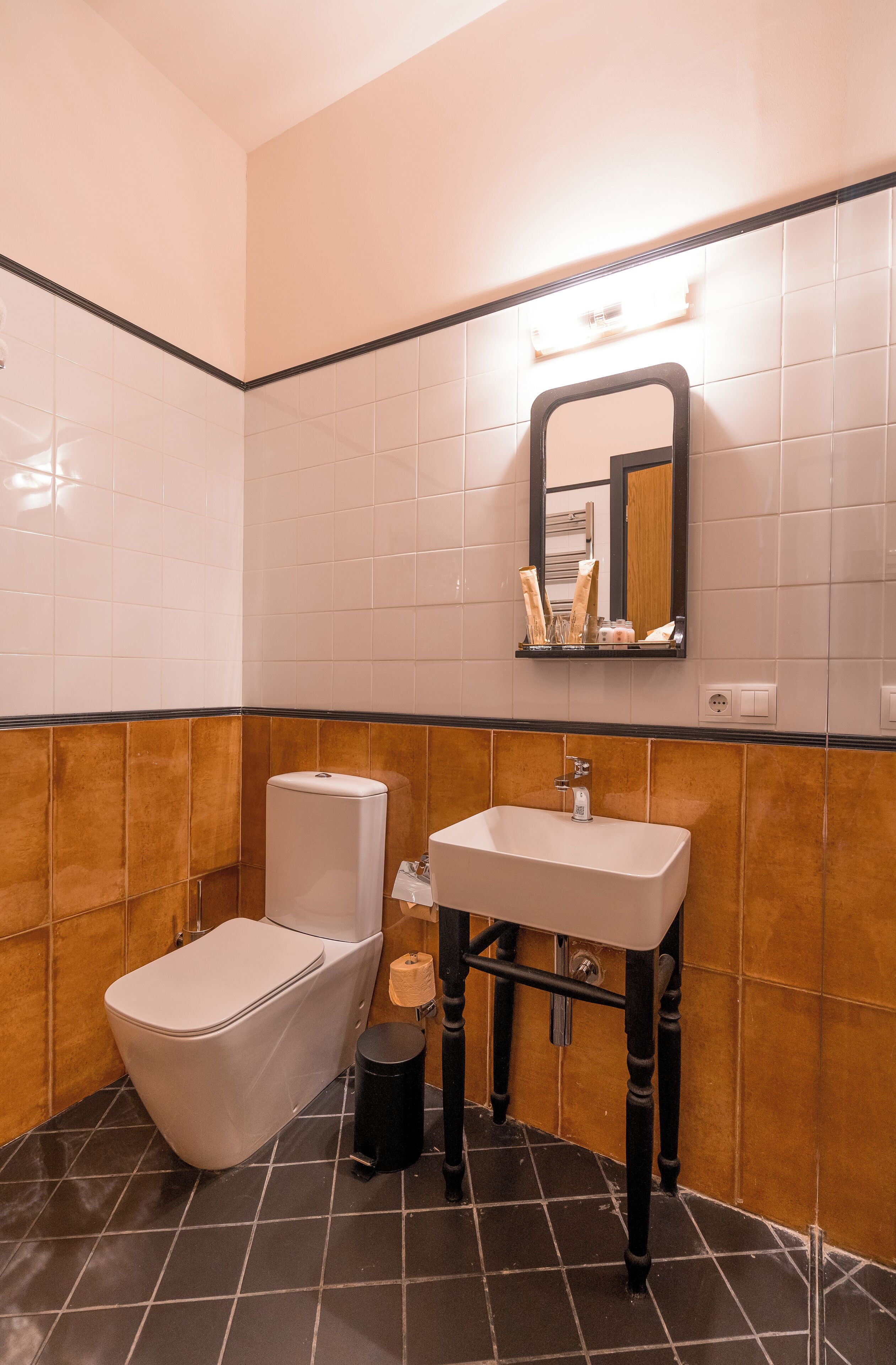 Un baño con inodoro, lavamanos y espejo.