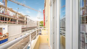 A construction site with a building under construction and a balcony with a view of the site.