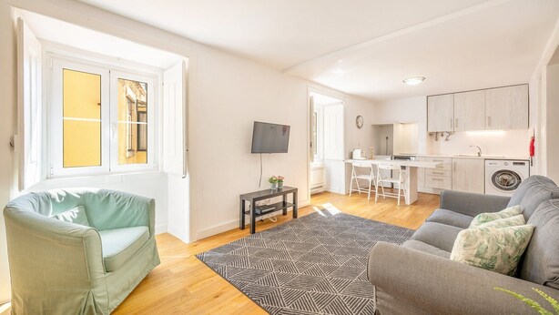 Een modern appartement met een woonkamer, keuken en een eethoek.
