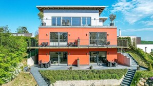 A modern two-story building with a flat roof, large windows, and a balcony. - Amselresidenz 1 - AMSEL (Binz)