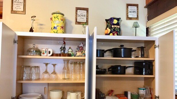 A kitchen with open cabinets displaying glassware, plates, and cooking pots. - Cute, Quiet And Meticulously Kept. This Private Studio Is Close To Everything.
 (Brandon)
