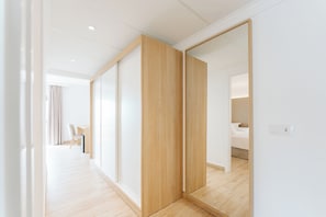 A modern hotel room with a large mirror, wooden flooring, and a view of the adjacent room. - R2 Buganvilla - All Inclusive (Pajara)