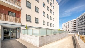 Ein modernes Gebäude mit Glasfassade, Beton-Eingang und Metallgeländer.