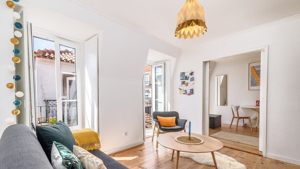 Un salon moderne avec un canapé gris, une table basse ronde et un fauteuil jaune.