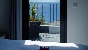 A bedroom with a bed, a view of the sea, and a balcony with plants. - GuestReady - Leme Beach Breathtaking Views (Santa Cruz)