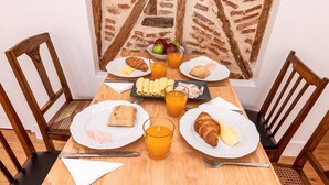 A breakfast table with croissants, cheese, ham, and juice glasses. - GuestReady - Sunny Chic in Santos (Lisbon)