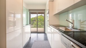 Una cucina moderna con un'ampia finestra, forno integrato e lavandino in acciaio inossidabile.