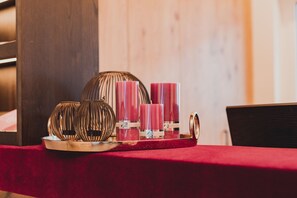 A table with decorative items including candles and a tray. - Portis Appartements (Dienten am Hochkoenig)