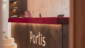 A reception desk with a wooden finish and the word "Portis" illuminated on it.