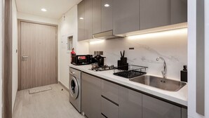 Une cuisine moderne équipée d ’appareils électroménagers en acier inoxydable, d’un four encastré et d’un évier.