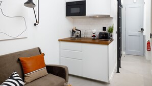 A compact kitchen with a built-in oven, a toaster, and a coffee maker. - Saudade Micro Lofts (Lisbon)