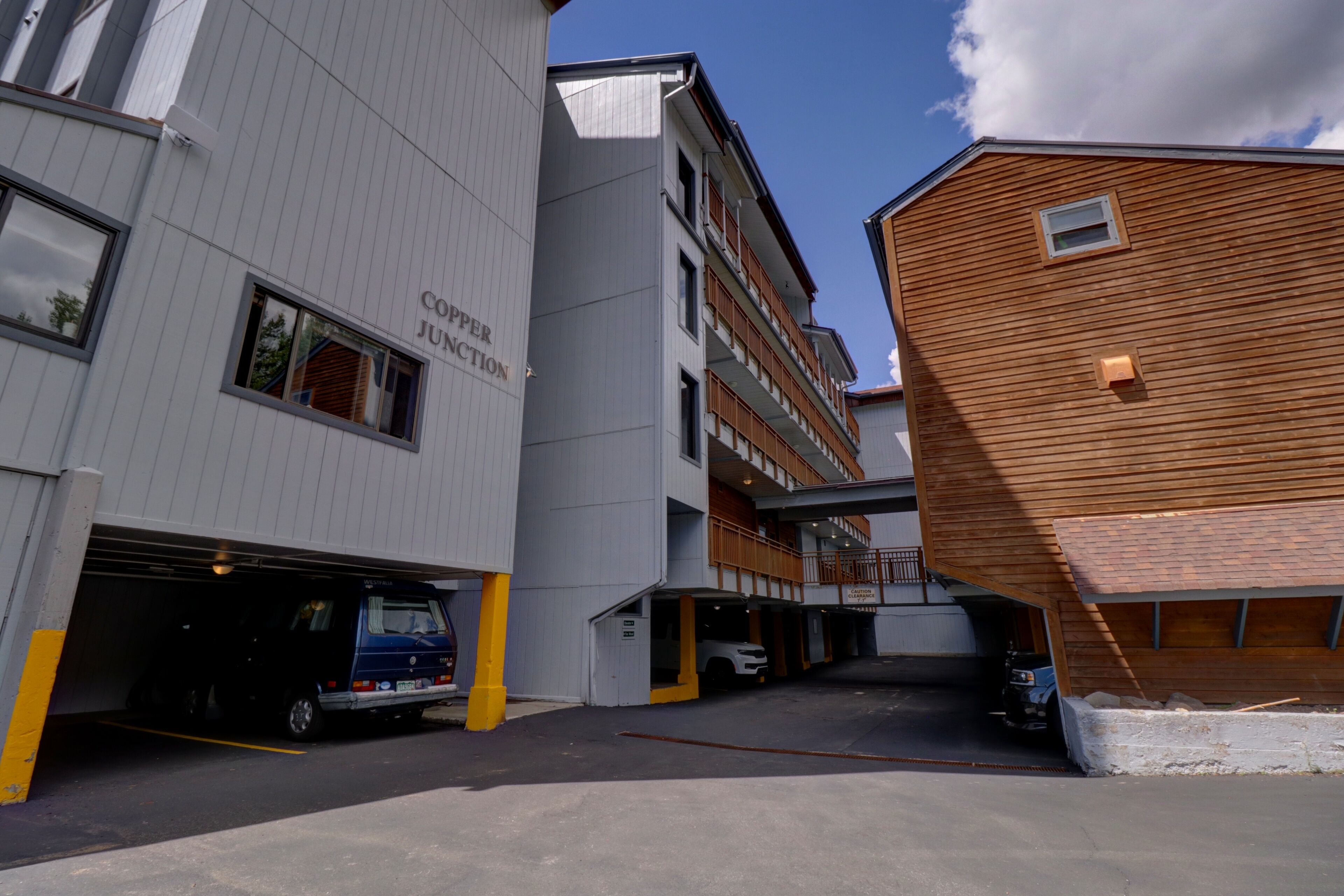 A multi-story parking garage with a blue van and a white car parked inside.