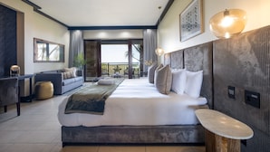 Ein modernes Hotelzimmer mit einem großen Bett, einem Schreibtisch und Blick ins Freie.