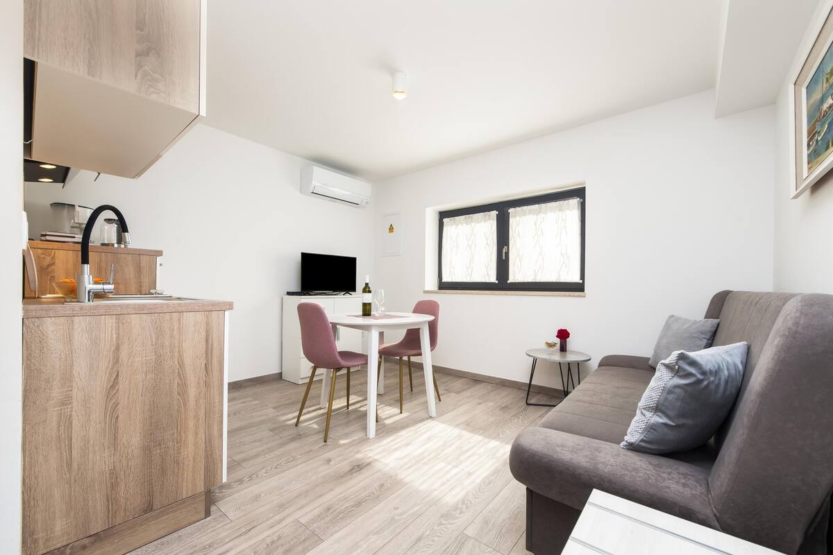 A compact living space with a kitchenette, a dining area, and a seating area.