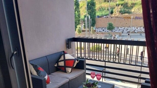 A balcony with a sofa, a small table, and a railing. - J u b i l e h o u s e R o m e (Roma)