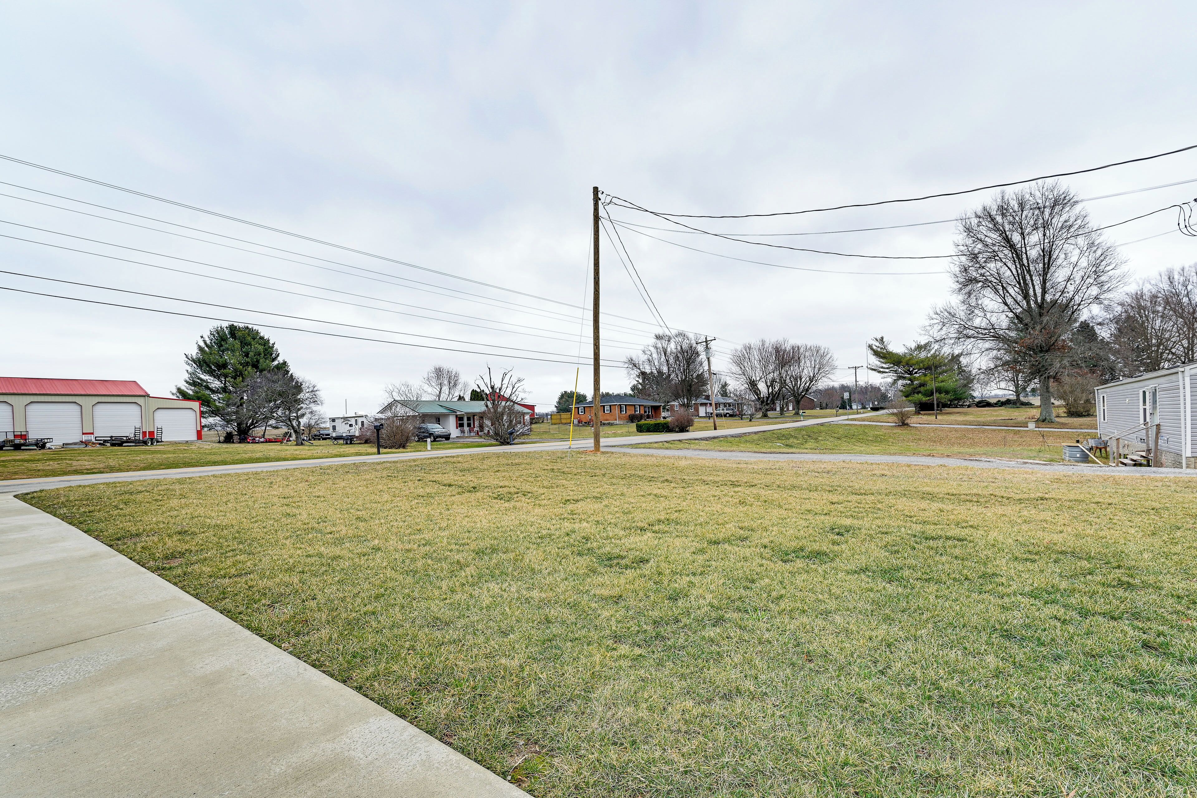 A residential area with houses, a grassy lawn, and a concrete sidewalk.