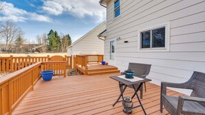 A deck with a table and chairs, a blue bucket, and a wooden railing. - Charming Country Home in Laramie - 4 Mi to UW! (Laramie)
