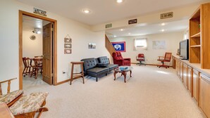 A spacious living room with a sofa, chairs, a coffee table, and a television. - Charming Country Home in Laramie - 4 Mi to UW! (Laramie)