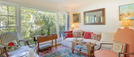 A cozy living room with a sofa, armchairs, a coffee table, and a patterned rug.