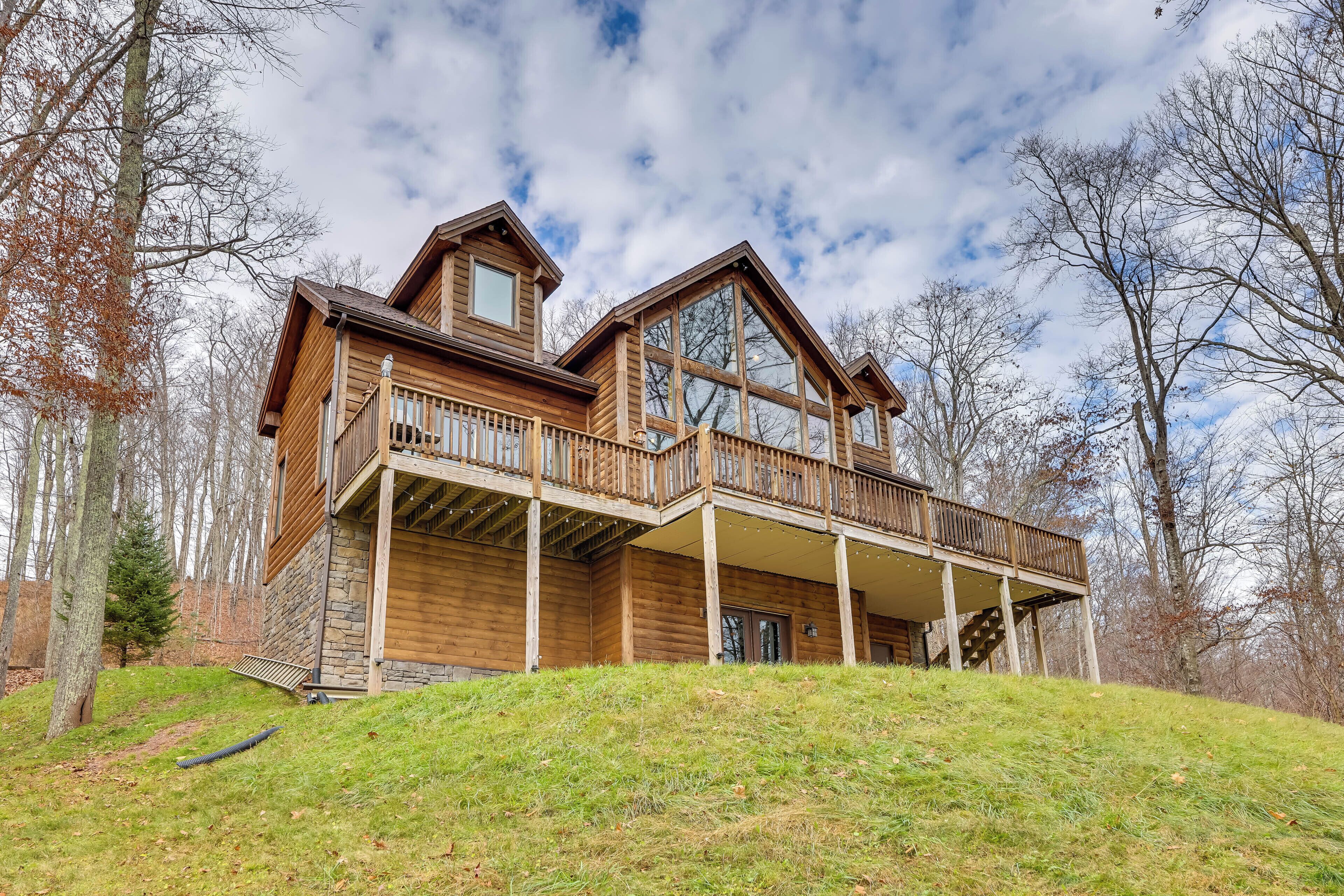 A log cabin with a balcony and a stone foundation.