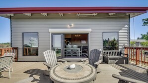 Um terraço com uma mesa redonda, cadeiras e uma lareira embutida.