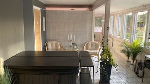 A modern outdoor patio with a hot tub, seating area, and potted plants. - Norrfällsvikens Rum & Kök (Mjällom)
