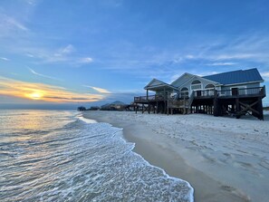 Une propriété située en bord de mer, dotée de plusieurs terrasses en bois et d’une grande maison.