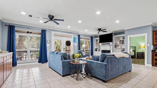 A spacious living room with a large sofa set, a small round table with a vase, and a ceiling fan. - Stay like a local in this pet-friendly home with private pool!  (Dauphin Island)