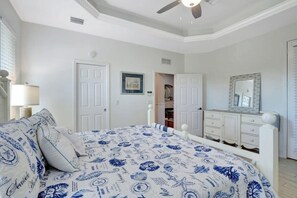 A bedroom with a bed, a dresser, a mirror, and a door leading to a closet.