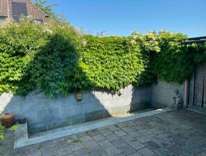 Surrounded by lush greenery, this historic wall features a decorative stone plaque.