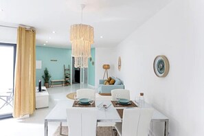 Cozy living space with a dining table for four, sofa, and floor lamp.