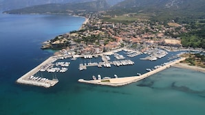 An aerial view of a coastal town with a marina, surrounded by mountains and a clear blue sea. - Villa Avec Piscine, en Pleine Nature et a 5 Minutes de Saint Florent ! (Santo-Pietro-di-Tenda)
