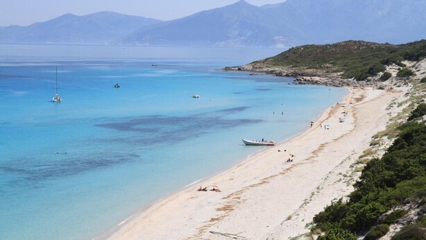 A beach with clear turquoise water, boats, and a mountainous backdrop. - Villa Avec Piscine, en Pleine Nature et a 5 Minutes de Saint Florent ! (Santo-Pietro-di-Tenda)