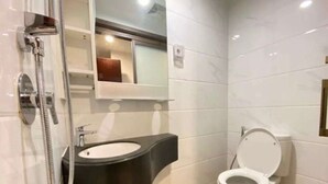 A bathroom with a modern sink, toilet, and shower. - Sky House BSD by Kakarama Room (Pagedangan)