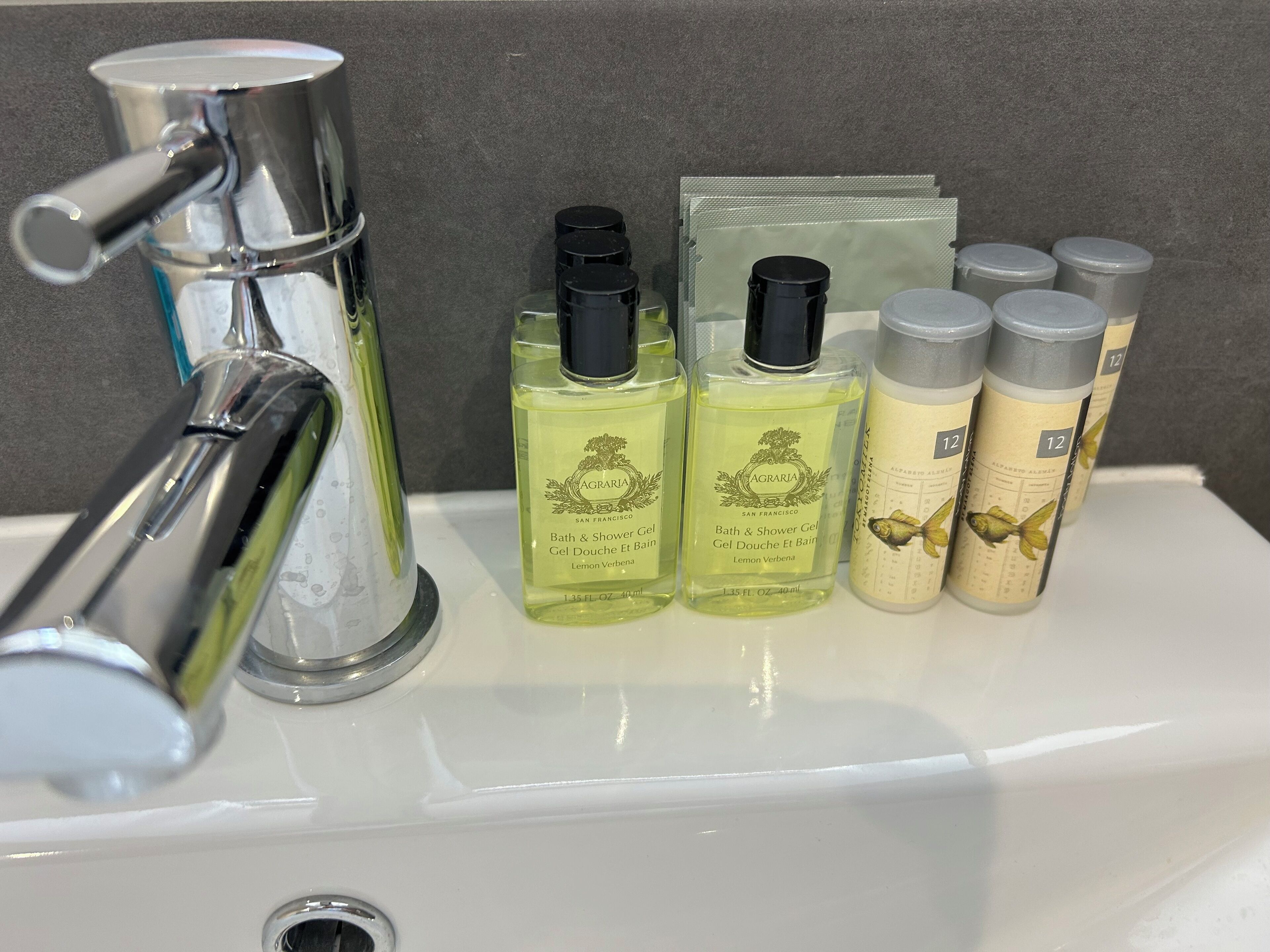 Un lavamanos con un grifo cromado y varias botellas de productos de baño.