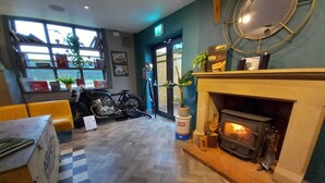 A cozy interior with a fireplace, a motorcycle, and a checkered floor. - The Stag (Alcester)