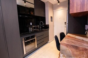 Enjoy meals in this kitchen with sleek cabinetry, stainless steel appliances, and a dining area.