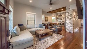 A spacious living room with a sectional sofa, a coffee table, and a patterned rug.