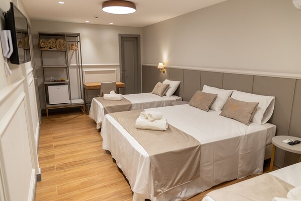 A hotel room with two beds, a small desk, a wardrobe, and a round table. - Pousada e Cerimonial Itamaraty (Domingos Martins)