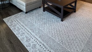 Una sala moderna con un sofá modular, una mesa de centro y una alfombra estampada.