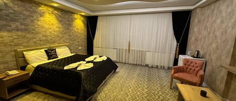 Una habitación de hotel moderna con una cama grande, un escritorio y una silla.