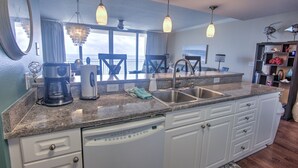 A kitchen with a dishwasher, a coffee maker, and a sink.
