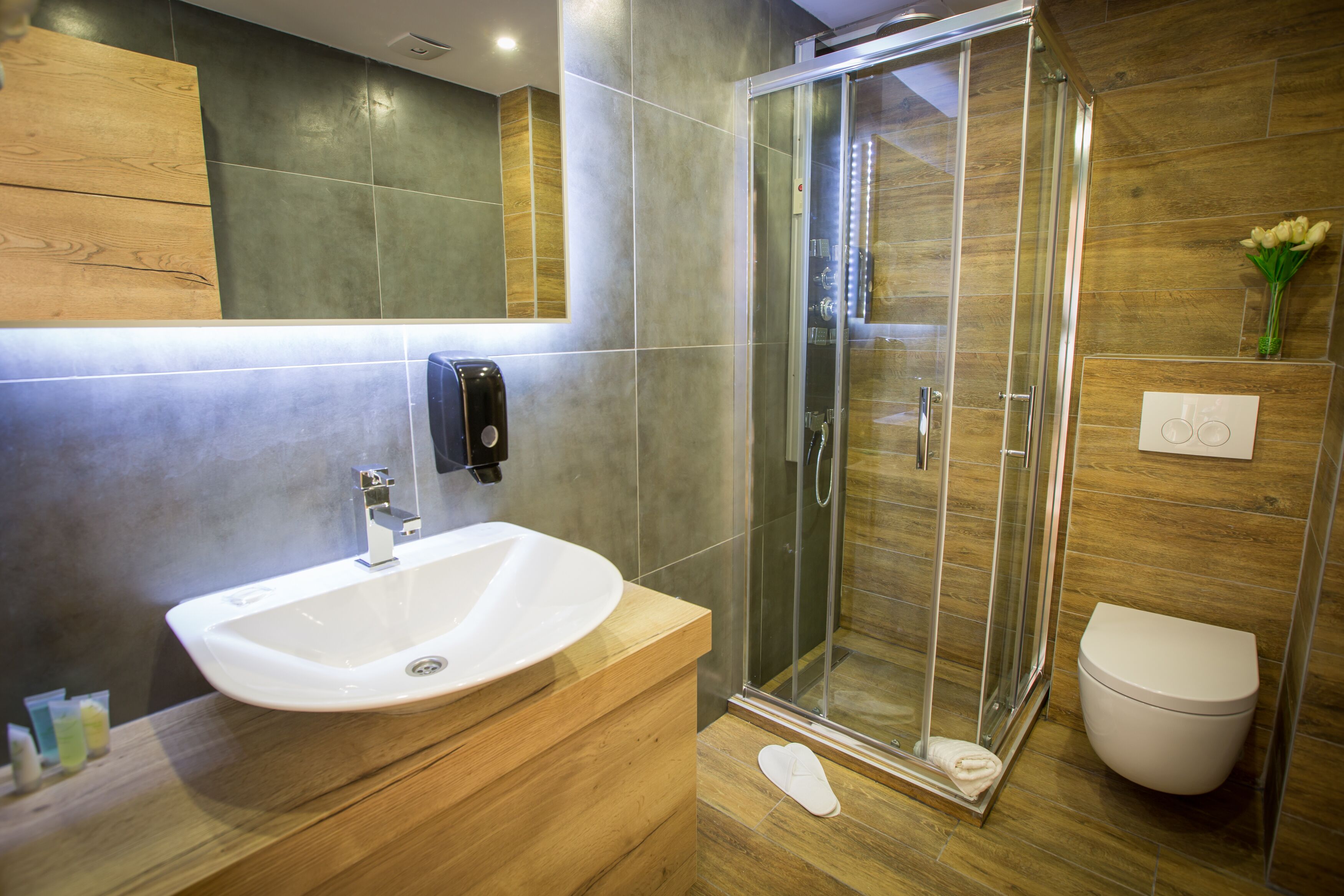 Une salle de bain moderne avec une douche à parois de verre, un lavabo blanc et des toilettes.