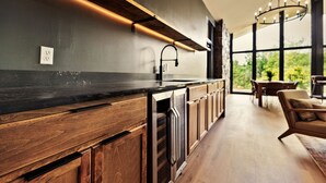 Una cocina moderna con armarios de madera, encimera negra y lavavajillas integrado.