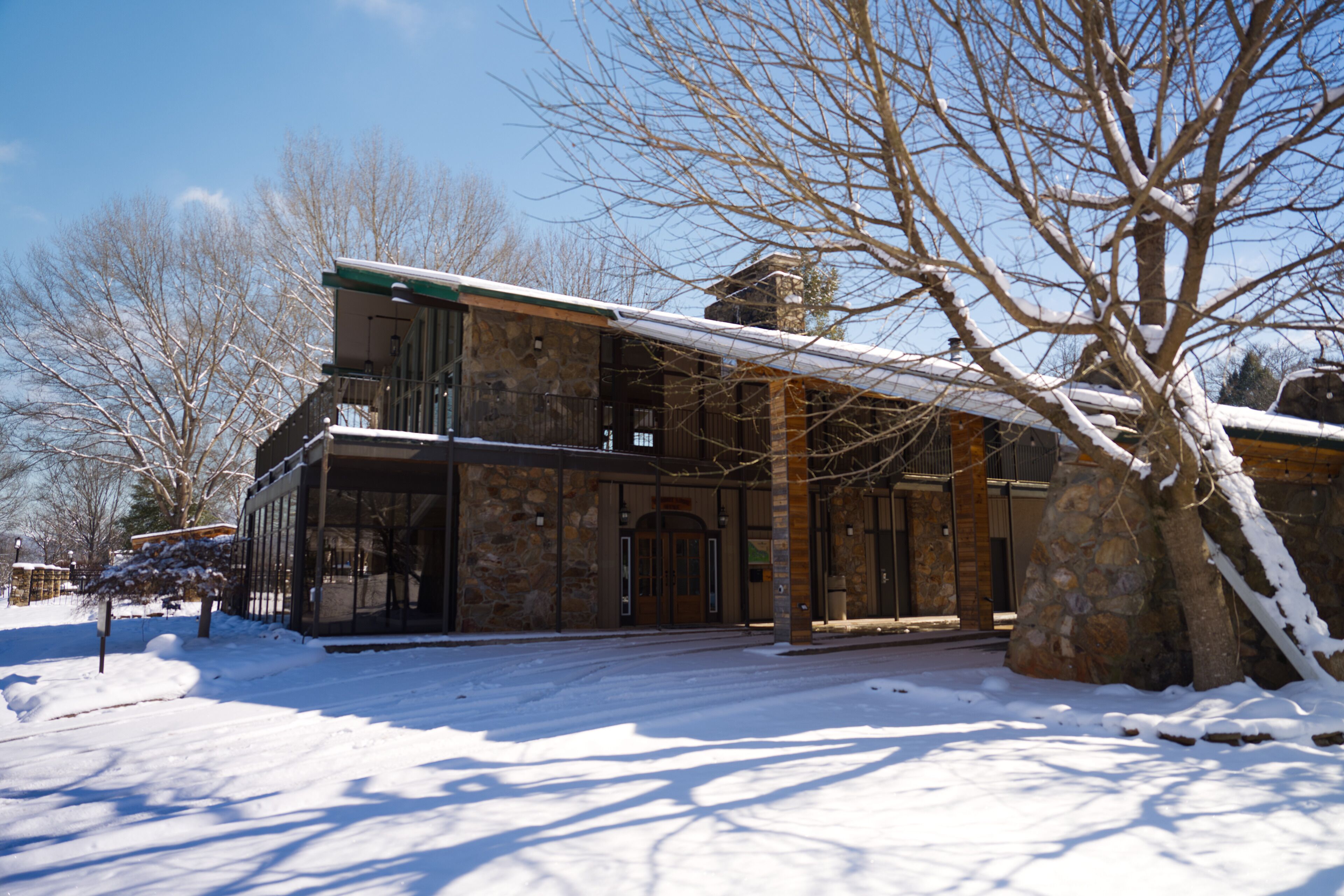 A stone building with a balcony and a snow-covered landscape.