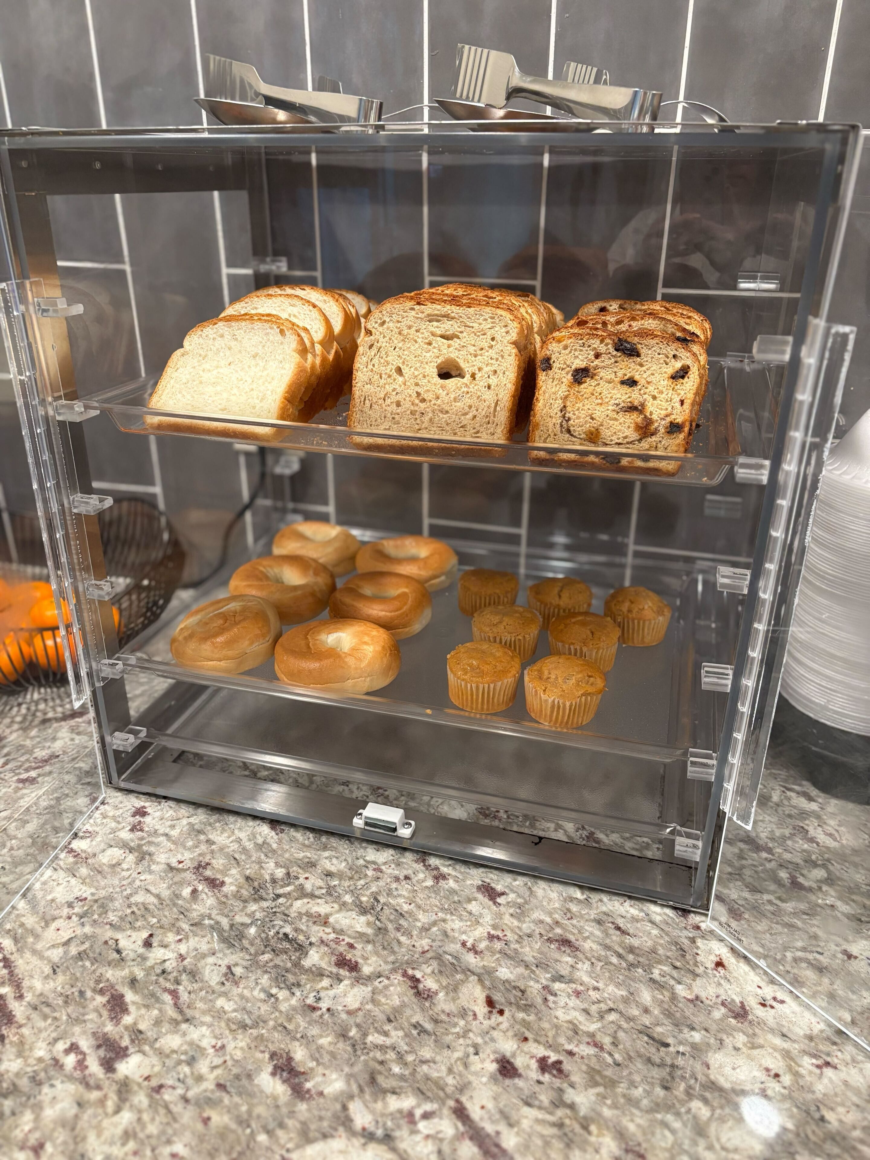 A bakery display case with bread and muffins.